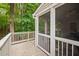 Inviting screened porch with white railings, offering a tranquil outdoor living space surrounded by trees at 227 Chimney Rise Dr, Cary, NC 27511