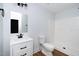 White bathroom with modern fixtures, a commode, and a shower-tub combo at 2517 Newbold St, Raleigh, NC 27603