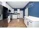 Modern kitchen with white cabinets, stainless steel appliances, quartz countertops, and stylish blue accent wall at 2517 Newbold St, Raleigh, NC 27603