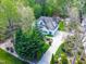 Stunning aerial view of a home with a long driveway and lush green landscaping and mature trees at 255 Williamston Ridge Dr, Youngsville, NC 27596