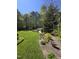 Expansive backyard with manicured lawn, lush gardens, a white gazebo and storage building at 255 Williamston Ridge Dr, Youngsville, NC 27596