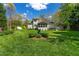 Spacious backyard with a manicured lawn, vibrant blue bird bath, mature trees, and well-maintained landscaping at 255 Williamston Ridge Dr, Youngsville, NC 27596