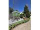 Charming greenhouse featuring a clear glass structure, surrounded by a gravel pathway and manicured garden at 255 Williamston Ridge Dr, Youngsville, NC 27596