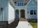 Welcoming front entrance with a stylish door, elegant fixtures, and manicured landscaping at 2617 Packhouse Rd, Zebulon, NC 27597
