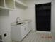Laundry room with patterned tile flooring, sink and cabinet, and shelving for easy organization at 2617 Packhouse Rd, Zebulon, NC 27597