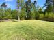 Expansive backyard featuring a large green lawn with a fence surrounded by lush trees at 30 Alvis Ct, Fuquay Varina, NC 27526