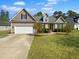 Inviting traditional home boasting manicured lawn, attached garage, and neutral siding under a sunny sky at 30 Alvis Ct, Fuquay Varina, NC 27526