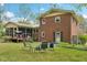 The expansive backyard features a brick home, a screened in porch and outdoor seating around a fire pit at 3011 Kenan Rd, Durham, NC 27704