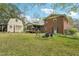 Large backyard featuring a brick home, storage shed, screened porch, and seating area at 3011 Kenan Rd, Durham, NC 27704