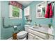 Clean and tidy bathroom featuring a white vanity, toilet, hand rails, and a window for natural light at 3011 Kenan Rd, Durham, NC 27704