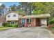 Inviting brick home with covered carport, mature trees, and well-maintained landscaping at 3011 Kenan Rd, Durham, NC 27704