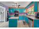Colorful kitchen featuring turquoise cabinetry, an island, and stainless appliances at 3011 Kenan Rd, Durham, NC 27704