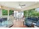 Cozy screened-in sunroom with a ceiling fan, string lights, and a comfortable seating area for relaxing at 3011 Kenan Rd, Durham, NC 27704