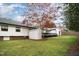 Large backyard featuring a well-maintained lawn, white shed, a deck and mature tree canopy at 3016 Sylvania Dr, Raleigh, NC 27607