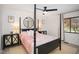 This primary bedroom features a four-poster bed, ceiling fan, and bright natural light at 3016 Sylvania Dr, Raleigh, NC 27607