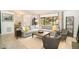 Cozy living room featuring a large gray sectional, neutral rug, accent chairs, and a large window showcasing the outdoors at 3016 Sylvania Dr, Raleigh, NC 27607