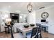 Open-concept dining area with a wooden table, modern lighting, and seamlessly connected to the living room and work space at 306 Deodora Ln, Cameron, NC 28326
