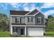 Two story home with blue accent shutters, and a gray garage door at 306 Deodora Ln, Cameron, NC 28326