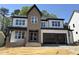 Two-story home with large windows, brick accents, and an attached two-car garage in a well-lit area at 3412 Amelia Grace Dr # 43, Fuquay Varina, NC 27526