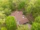 Aerial view of home with a beautiful brown roof nestled among lush, green trees at 3518 Travis Ct, Chapel Hill, NC 27516