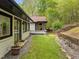 Inviting backyard featuring a brick house, raised garden beds, and a detached screened-in porch at 3518 Travis Ct, Chapel Hill, NC 27516