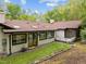 Backyard view of a white brick home featuring a deck, large windows, skylights, and green grass at 3518 Travis Ct, Chapel Hill, NC 27516