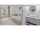 Bathroom featuring a large soaking tub, glass enclosed shower, vanity and unique stained-glass window at 3518 Travis Ct, Chapel Hill, NC 27516