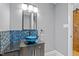 Modern bathroom featuring a stylish vessel sink, dark vanity, and unique blue tiled backsplash at 3518 Travis Ct, Chapel Hill, NC 27516