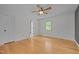 Bright bedroom features gleaming hardwood floors, a ceiling fan, and a window offering views of the surrounding greenery at 3518 Travis Ct, Chapel Hill, NC 27516