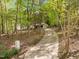 View of a long, paved driveway winding through lush trees leading up to a house at 3518 Travis Ct, Chapel Hill, NC 27516
