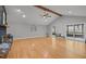 Bright living room featuring hardwood floors, vaulted ceiling with wood beam, fireplace and screened in porch access at 3518 Travis Ct, Chapel Hill, NC 27516