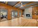 Open-concept space with a stone fireplace, hardwood floors, and a scenic backyard view at 3518 Travis Ct, Chapel Hill, NC 27516