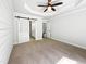 Spacious main bedroom features a ceiling fan, modern tray ceiling, and sliding barn door to the ensuite bathroom at 3638 Pine Needles Dr, Wake Forest, NC 27587