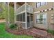 Exterior view of a screened porch, windchimes, and brick walkway at 3805 Chimney Ridge Pl # 003, Durham, NC 27713