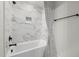 Bright bathroom displays a white tub with marble-look tiling and modern black shower fixtures at 382 Belmont Stakes Ln, Wendell, NC 27591