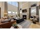 A bright living room boasts a soaring ceiling, fireplace, and large windows with backyard views at 382 Belmont Stakes Ln, Wendell, NC 27591