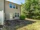 A townhouse backyard featuring a small grassy area, a door for access, surrounded by privacy and green foliage at 4901 Rose Quartz Way, Raleigh, NC 27610