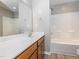 A well-lit bathroom with wood-look flooring, featuring a tub-shower combo, vanity, large mirror, and grey walls at 4901 Rose Quartz Way, Raleigh, NC 27610