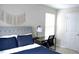 Cozy bedroom setup featuring a desk, chair, and macrame wall art above a tufted headboard with dark blue bedding at 4901 Rose Quartz Way, Raleigh, NC 27610