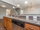 Kitchen area boasting granite countertops, wooden cabinets, and a stainless steel dishwasher at 4901 Rose Quartz Way, Raleigh, NC 27610