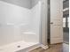 Bathroom shower with white walls and a door that leads to the bedroom at 4901 Rose Quartz Way, Raleigh, NC 27610