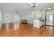 Bright, open living room with hardwood floors, ceiling fan, and a view to the kitchen and outdoor balcony at 501 Finsbury Street # 103, Durham, NC 27703