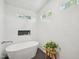 Modern bathroom featuring a standalone tub, black tile flooring, and clean white walls at 511 Circle Dr, Burlington, NC 27215