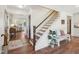 Inviting entryway with hardwood floors, staircase with wood treads, and bench seating with decorative pillows at 511 Circle Dr, Burlington, NC 27215