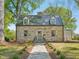 Beautiful stone house with dormer windows and mature trees in a landscaped front yard at 511 Circle Dr, Burlington, NC 27215