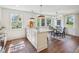 Bright kitchen features an island with marble countertop, dining space with window views, and hardwood floors at 511 Circle Dr, Burlington, NC 27215