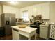 Updated kitchen boasts stainless steel appliances, bright white cabinets, and center island at 513 Orange St, Oxford, NC 27565