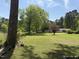Large grassy backyard featuring outbuildings and mature trees at 5138 Nc 56, Franklinton, NC 27525