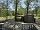 View of outbuildings in a large grassy backyard shaded by mature trees at 5138 Nc 56, Franklinton, NC 27525