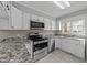 Bright kitchen with stainless steel appliances, granite countertops, and white cabinets at 541 Oak Run Dr, Raleigh, NC 27606